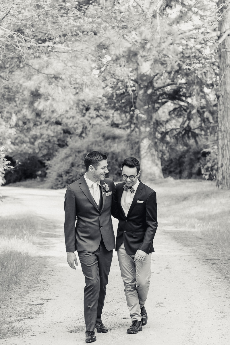 black and white photo of two grooms walking together at collingrove homestead