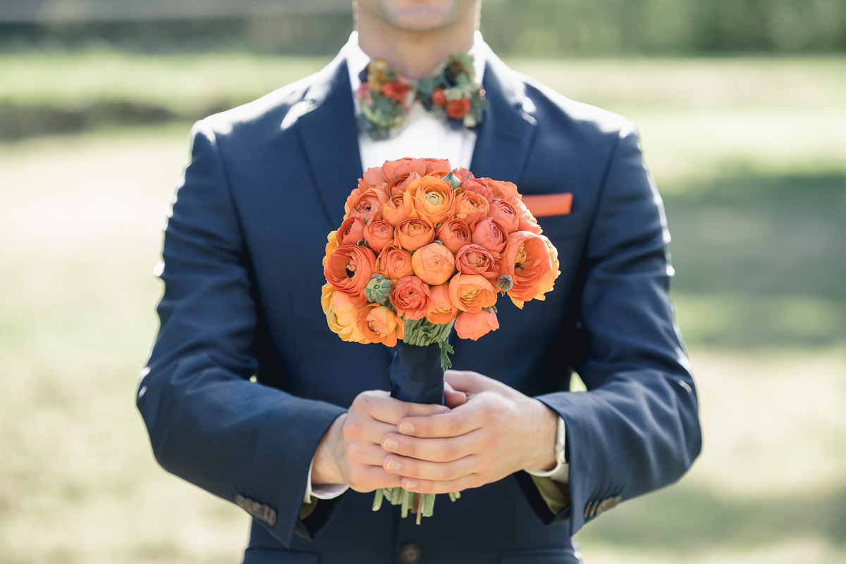 groom with orange bouquet flowers at collingrove homestead