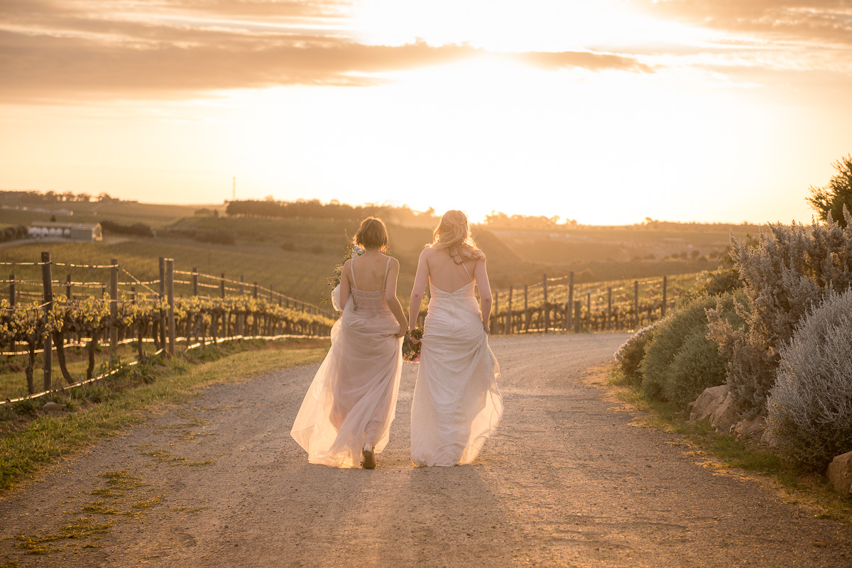 brides walking in to sunset at same sex wedding