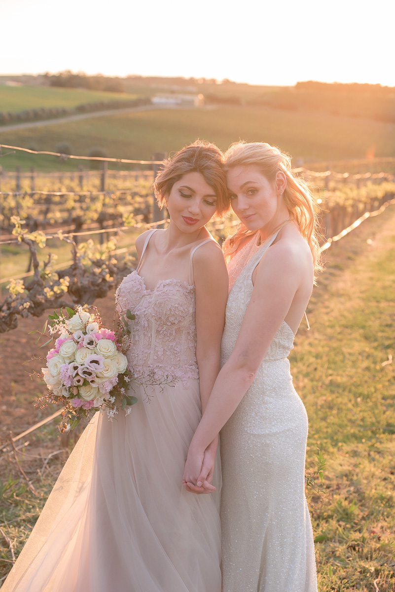 two brides holding hands at same sex wedding