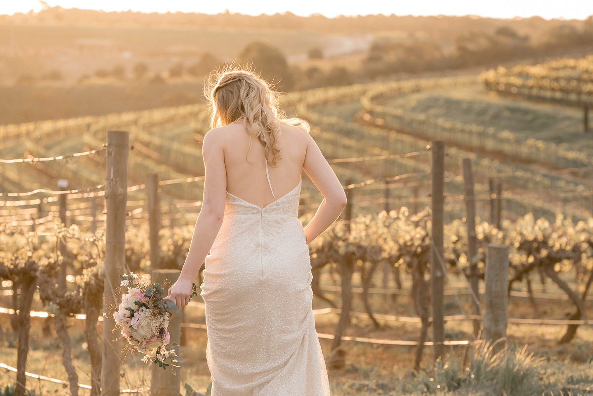 bride wandering in to vineyard at same sex wedding