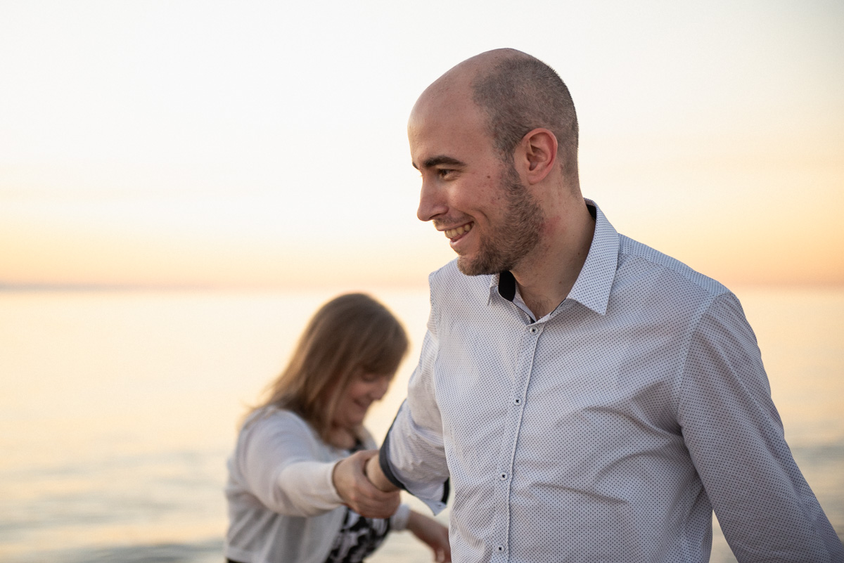 smiling couple engaged at grange beach