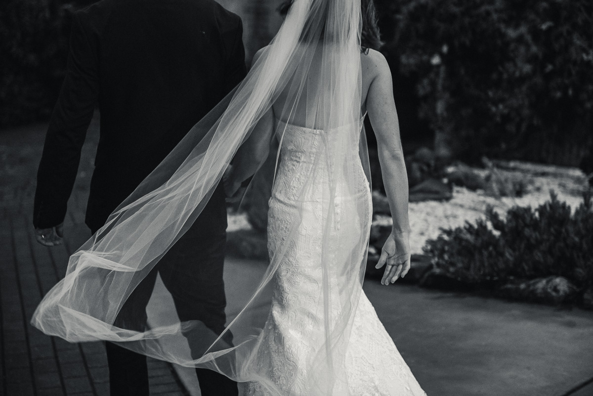 couple walk away from wedding photographer