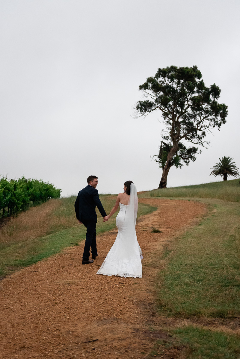 bride and groom walking up hill for wedding photo