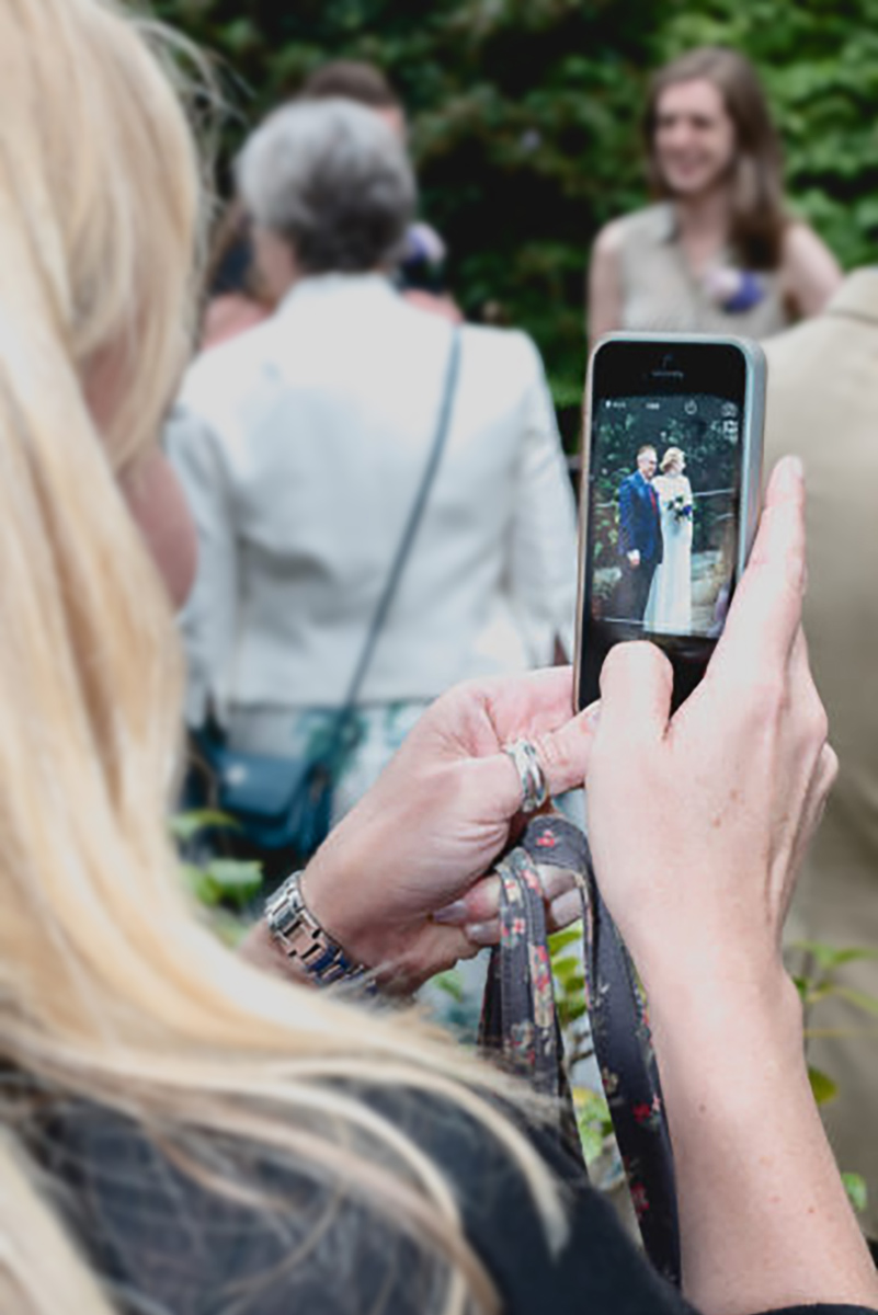 unplugged wedding guest waving camera