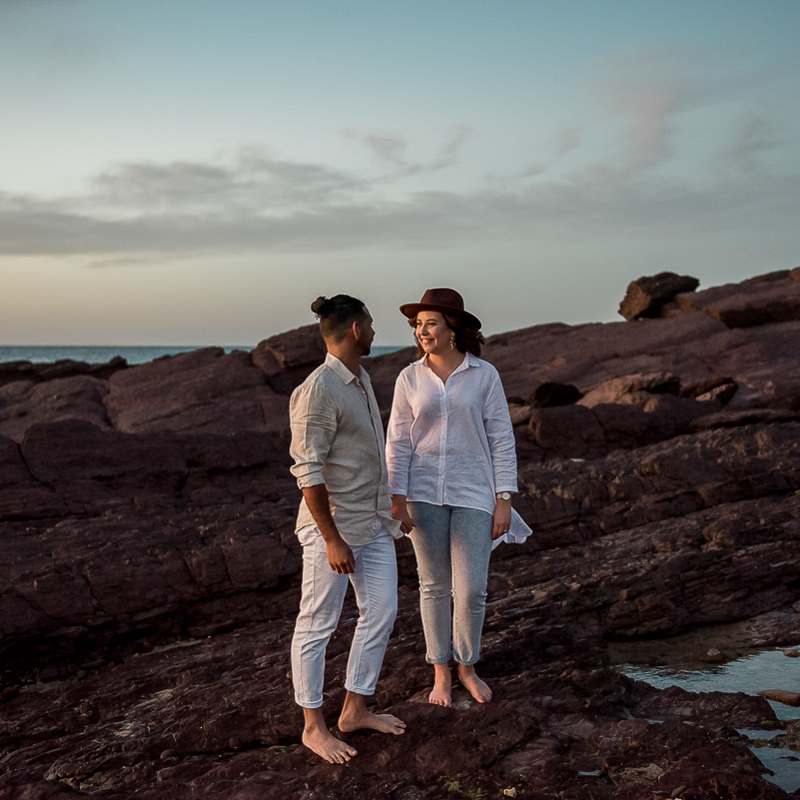 Walking together on rocks during engagement photography session