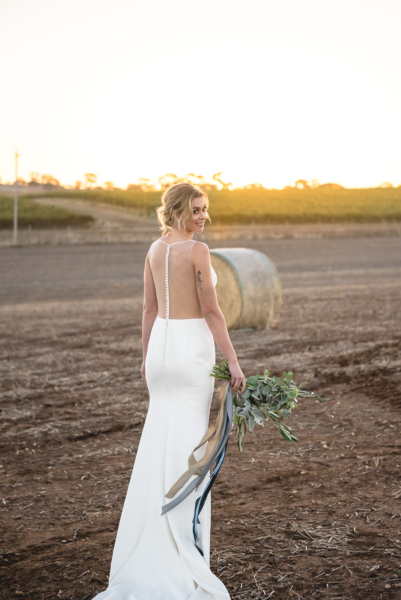 bride in a field at sunset