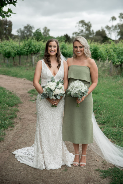 Bride and bridemaid portrait in fromt of vines in mclaren vale