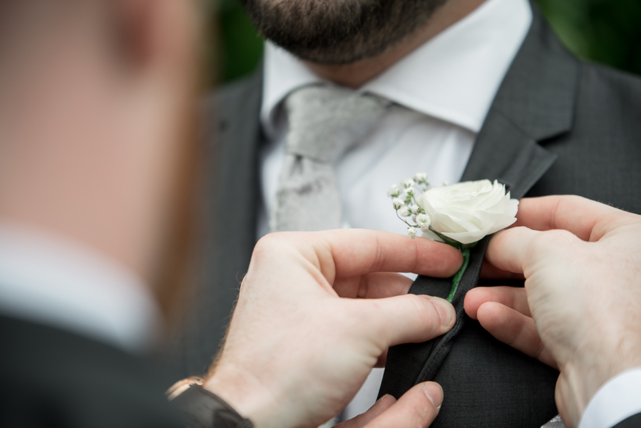 Attaching the button hole flowers at wedding